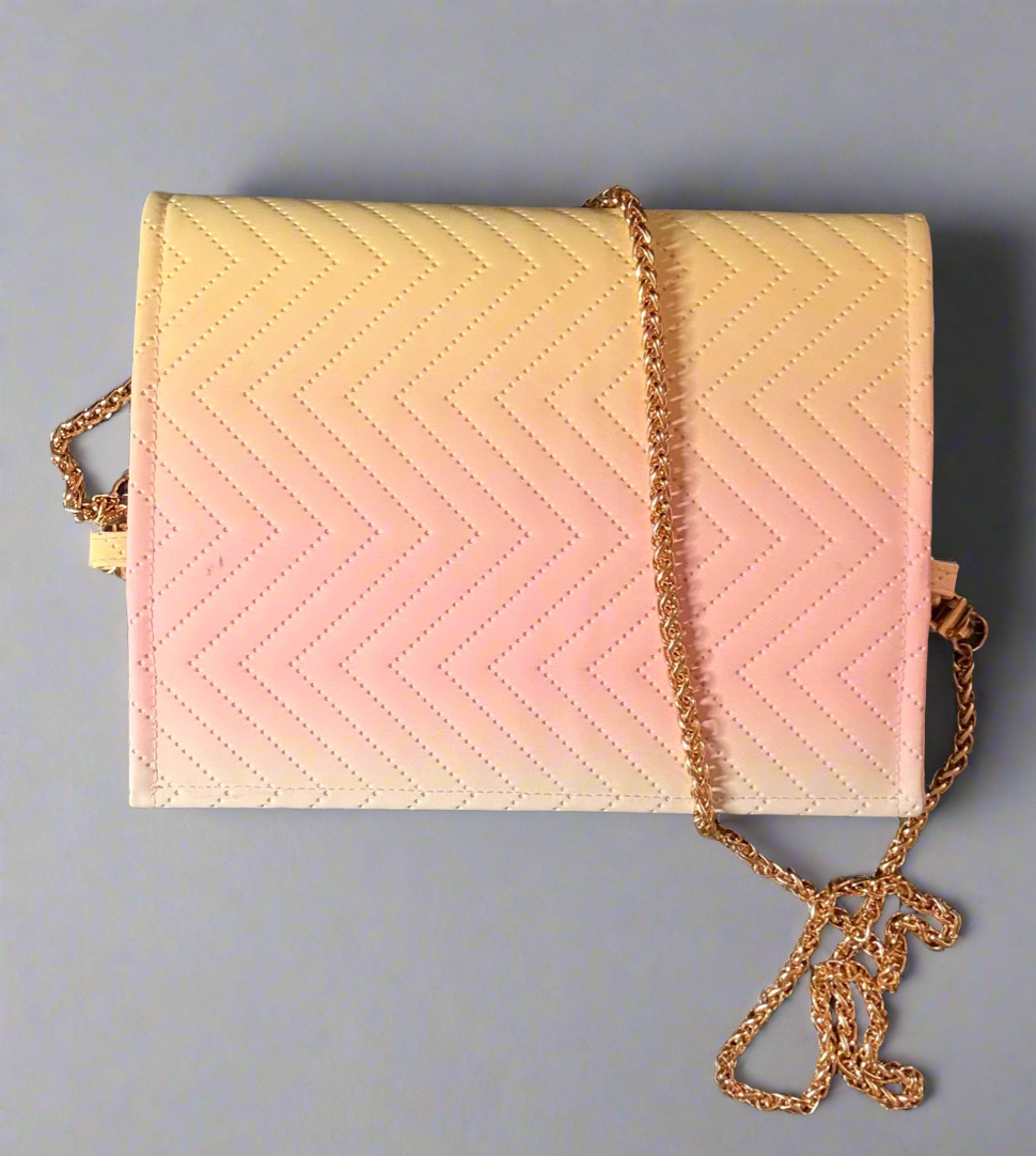 We see a small, rectangular clutch purse with a gold chain strap. The purse features a quilted chevron pattern in a gradient of pastel colors, transitioning from a light pink at the bottom to a pale yellow and then a very light green at the top flap.